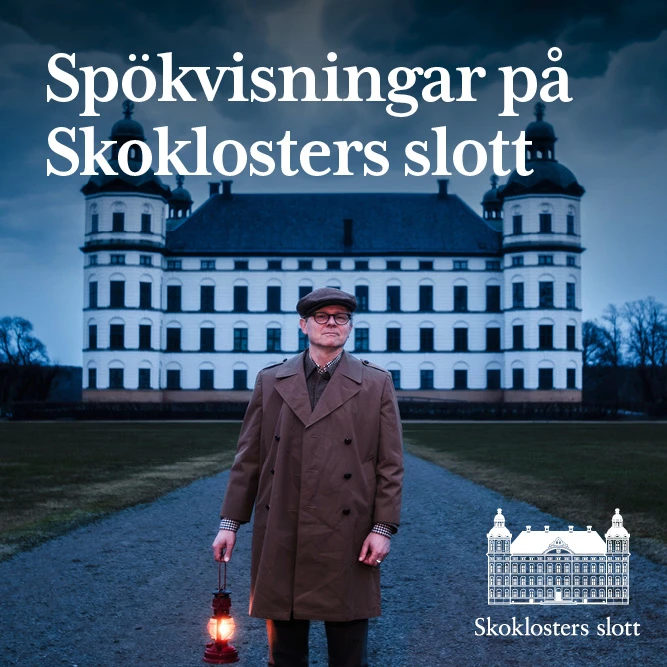 En man håller i en lykta med ett slott i bakgrunden.