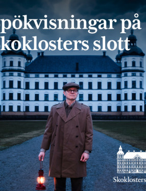 En man håller i en lykta med ett slott i bakgrunden.