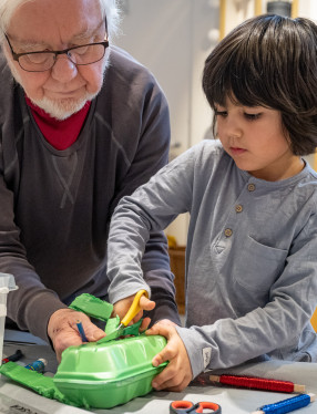 Vuxen och barnbarn skapar en båt tillsammans