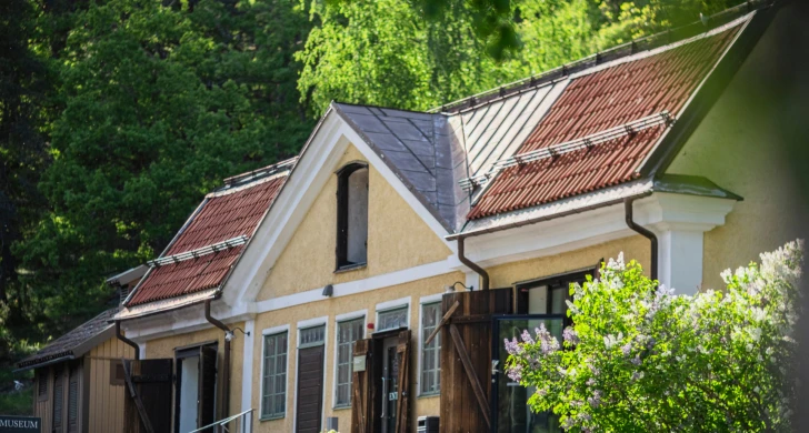 Ett hus med grönskande träd och syrener