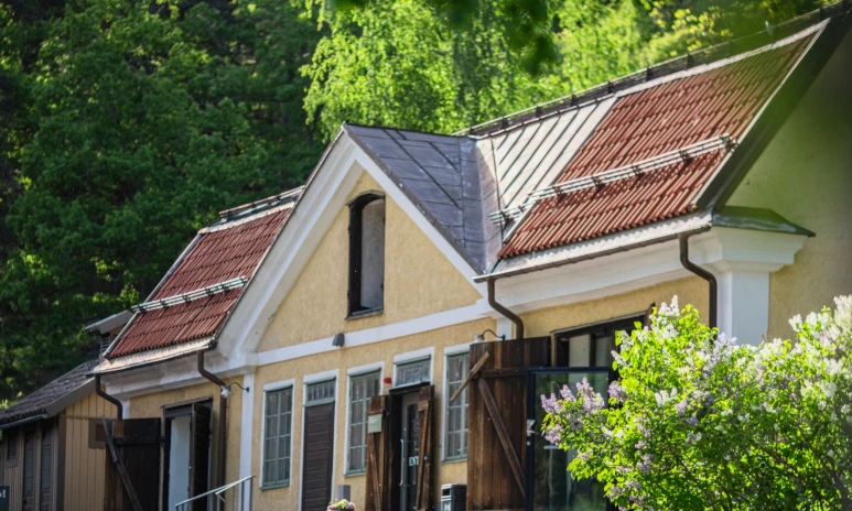 Ett hus med grönskande träd och syrener
