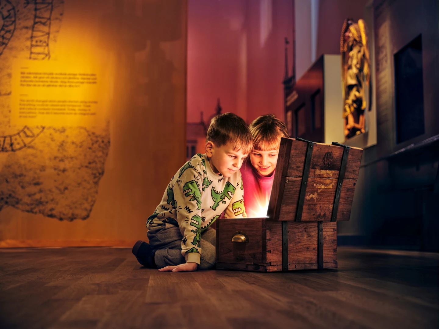 Två barn tittar ner i en skattkista som lyser