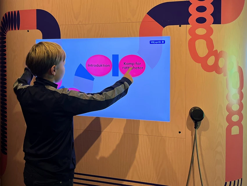 Ett barn trycker på en skärm om Kamp för rättigheter.