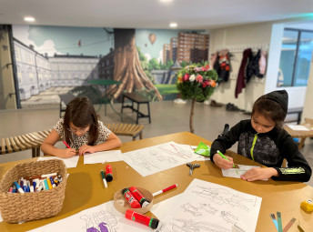Två barn tecknar vid ett bord.