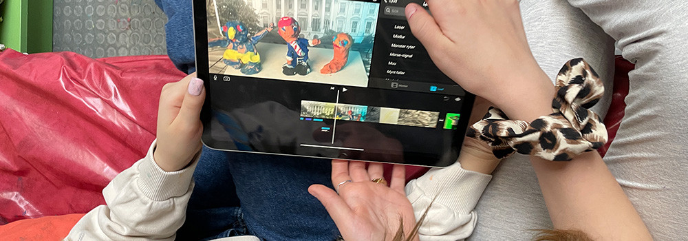 Händer håller i surfplatta med animerad film