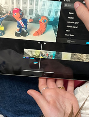 Händer håller i surfplatta med animerad film