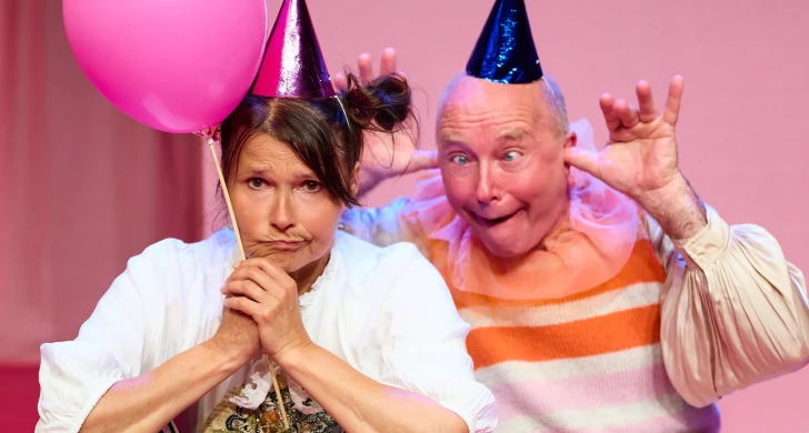 Två personer med partyhattar och ballong