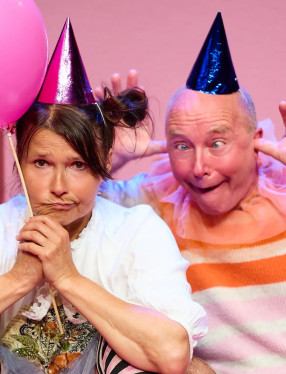 Två personer med partyhattar och ballong