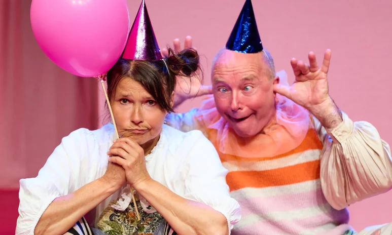 Två personer med partyhattar och ballong