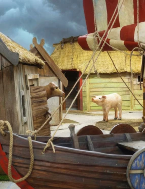 Lekutställning med vikingaskepp, hus och djur.