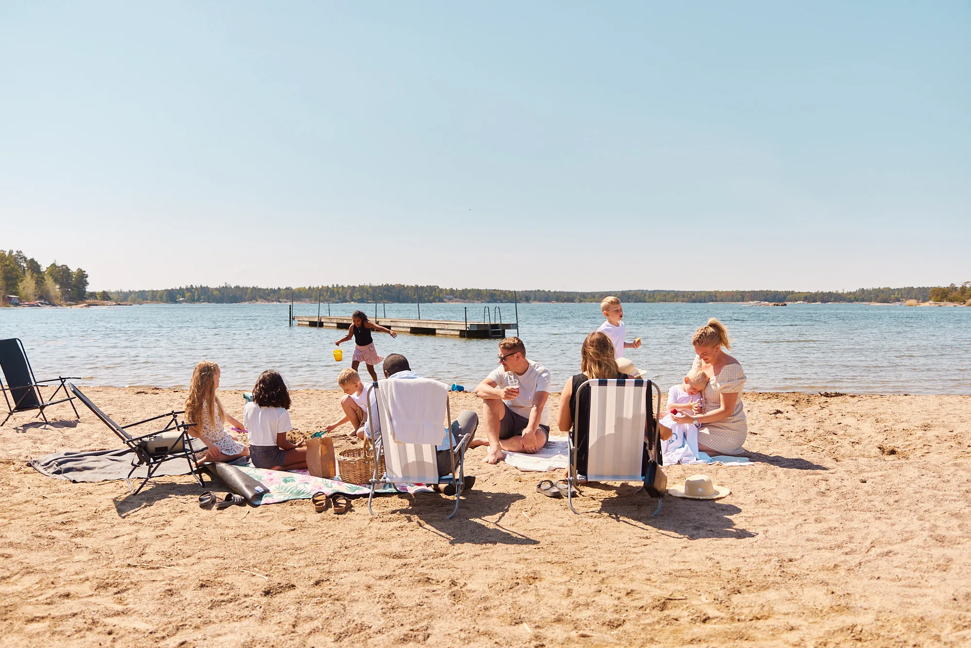 https://www.barnistan.se/wp-content/uploads/2026/04/Familjebild-vid-stranden-flera-personer-barn-och-vuxna-med-avstand-liggande.webp